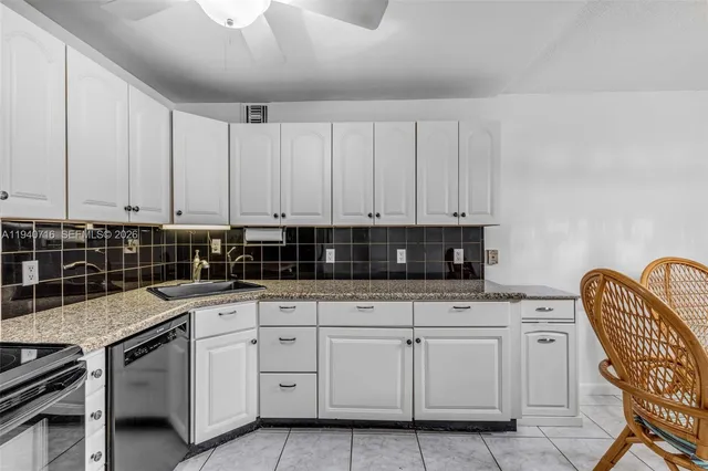 a kitchen with granite countertop white cabinets and white appliances