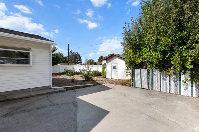 215 Carol Way Midvale, UT 84047 - Photo 29 of 30 Fenced backyard featuring a patio and a shed