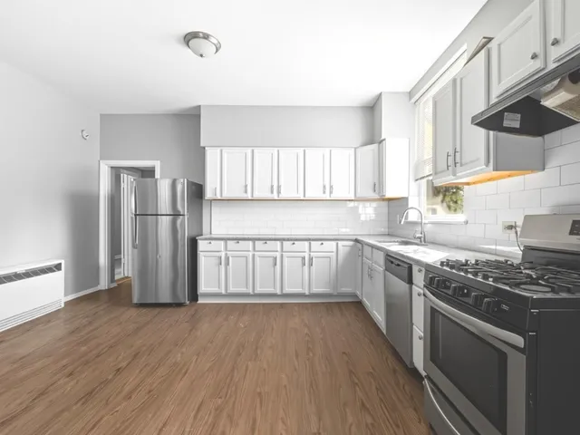 a kitchen with stainless steel appliances granite countertop a stove a sink and a refrigerator