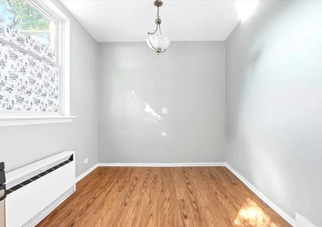 a view of a room with wooden floor and window