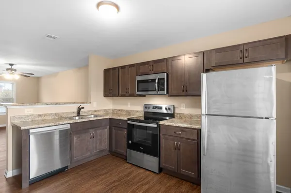 a kitchen with a sink a refrigerator a microwave a stove and cabinets