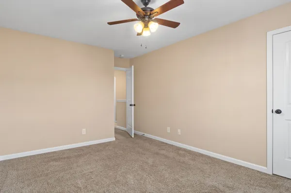 an empty room with a window and a fan