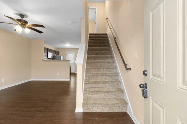 a view of a hallway with wooden floor and staircase
