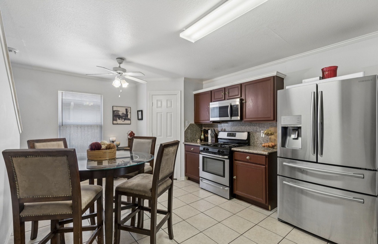 7118 Rising Brook Drive Cypress, TX 77433 - Photo 11 of 21 a kitchen with stainless steel appliances granite countertop a dining table and chairs