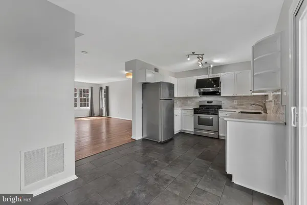 a kitchen with granite countertop a refrigerator and a stove top oven