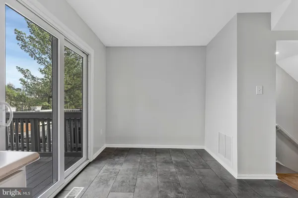 a view of an empty room with glass door and a window