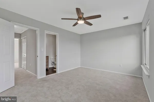 an empty room with closet and fan