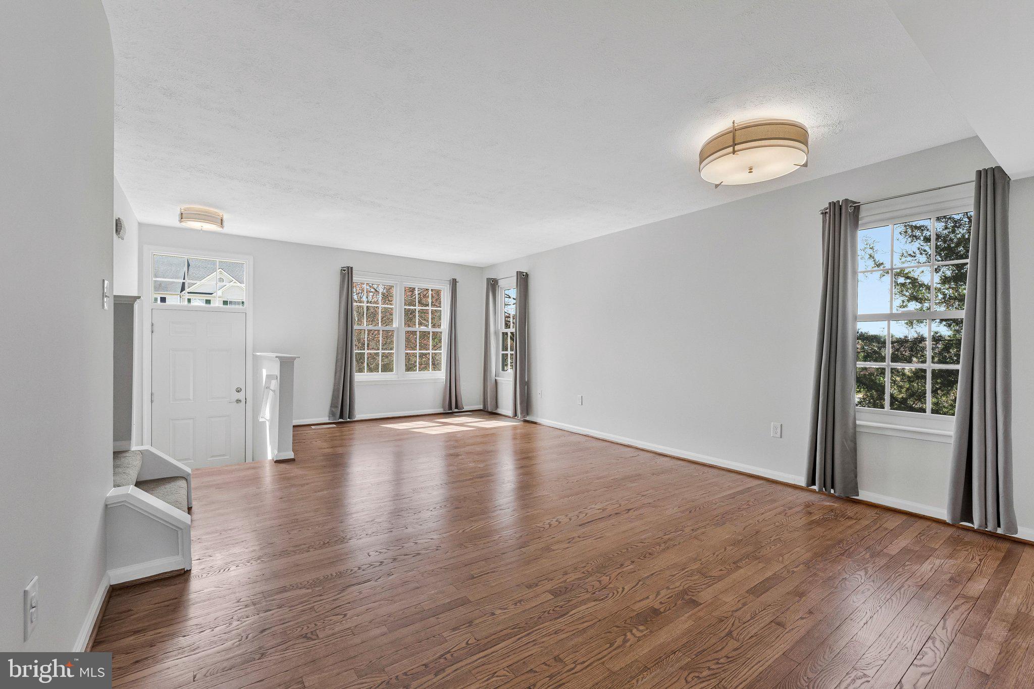 20718 Apollo Terrace Ashburn, VA 20147 - Photo 3 of 50 an empty room with wooden floor and windows