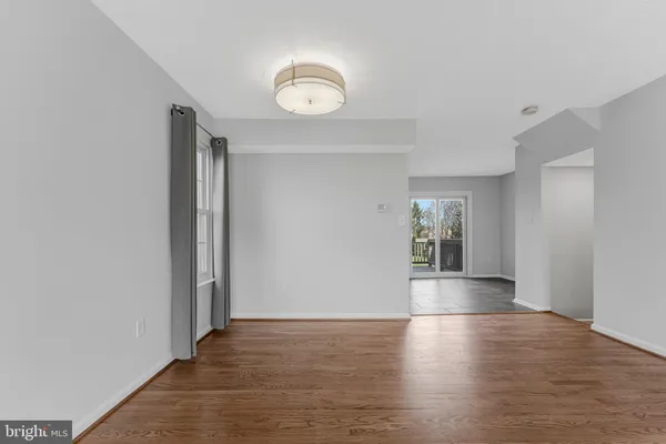 a view of empty room with wooden floor and window