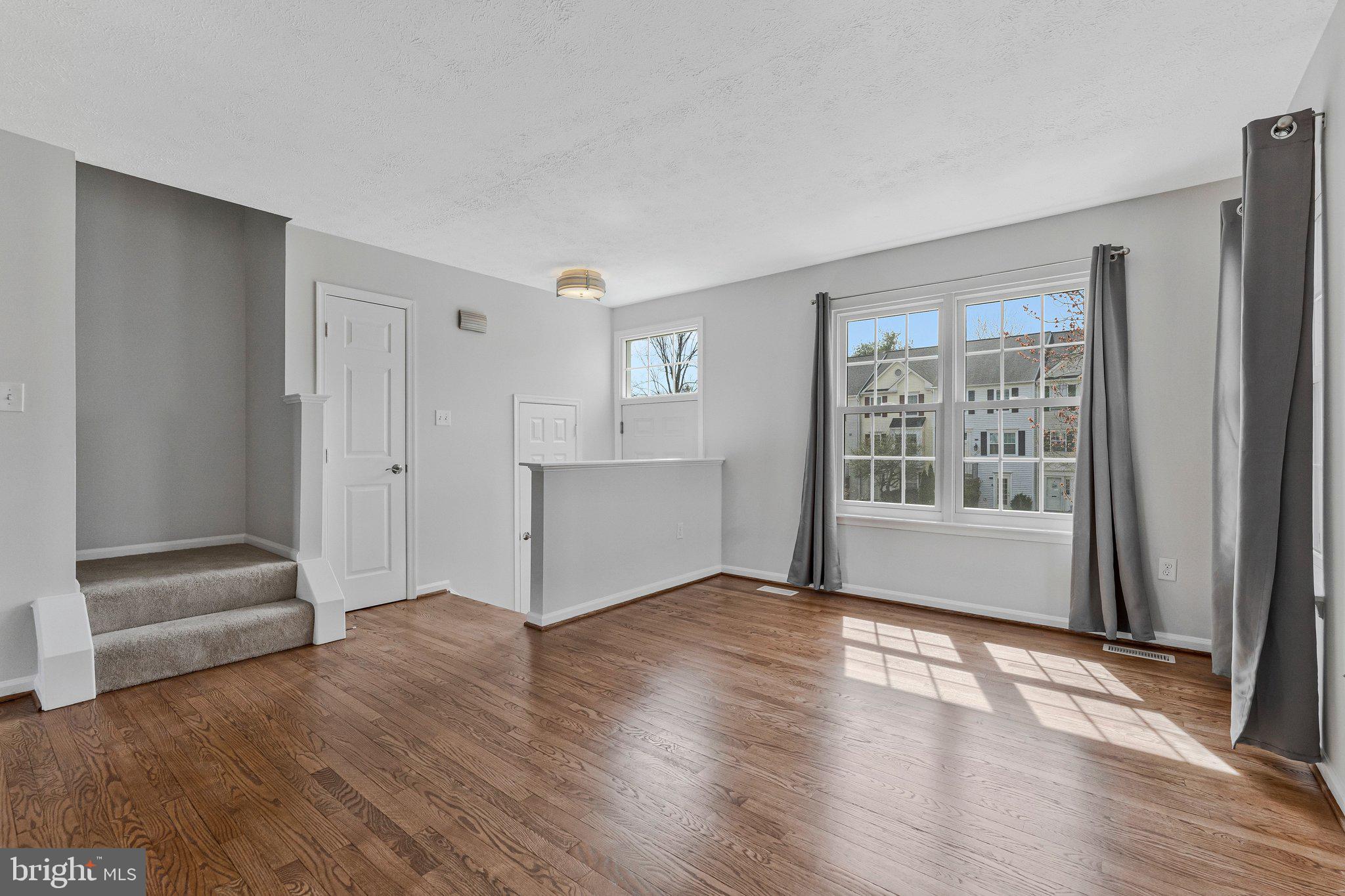 20718 Apollo Terrace Ashburn, VA 20147 - Photo 7 of 50 an empty room with wooden floor and windows