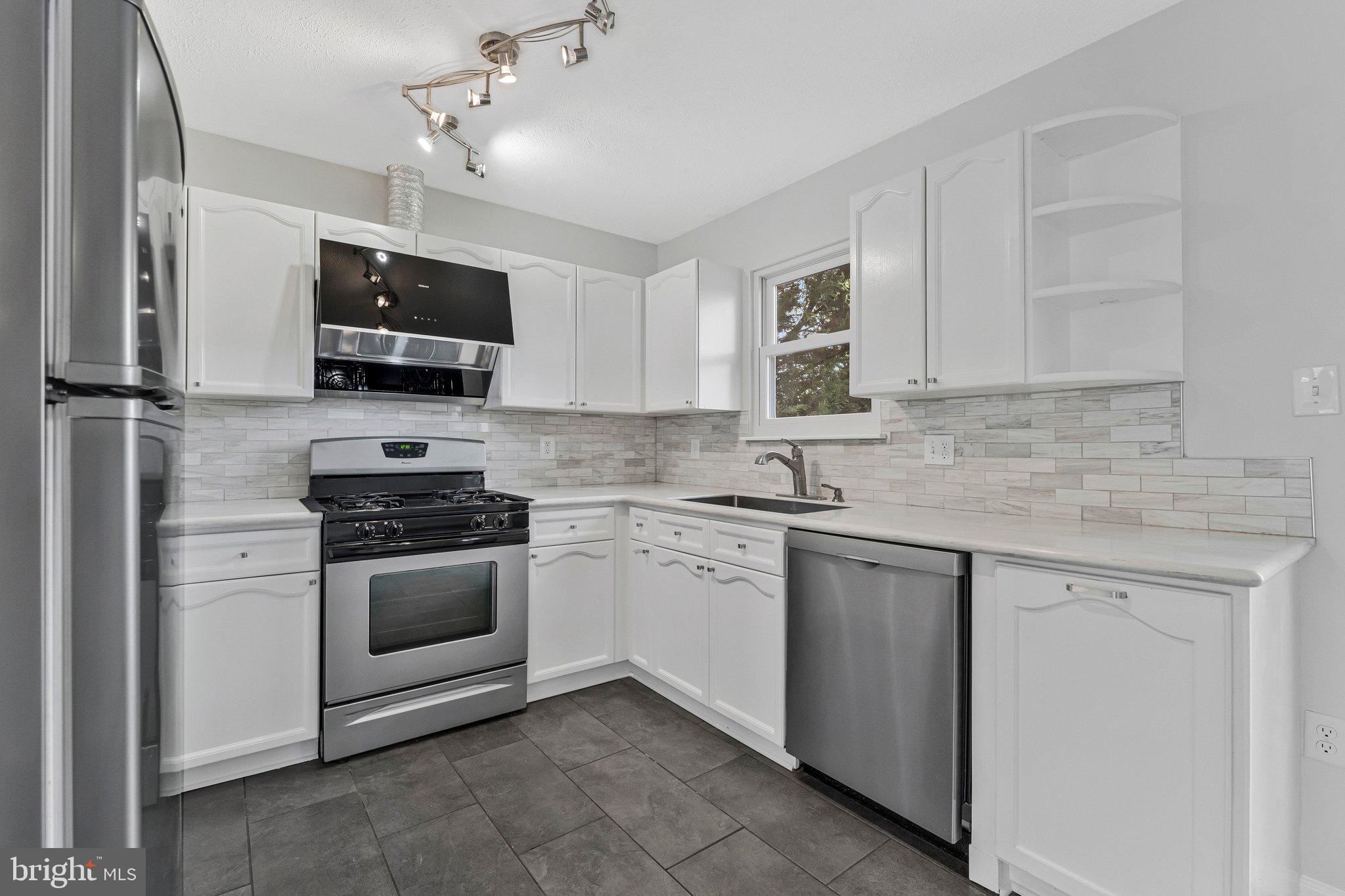 20718 Apollo Terrace Ashburn, VA 20147 - Photo 8 of 50 a kitchen with stainless steel appliances granite countertop a sink dishwasher a stove and a microwave oven with cabinets