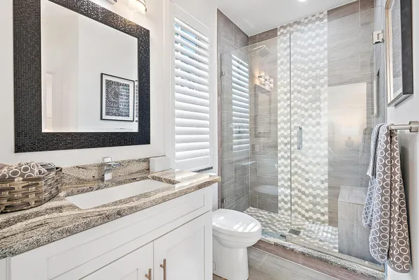 a bathroom with a granite countertop sink toilet and shower