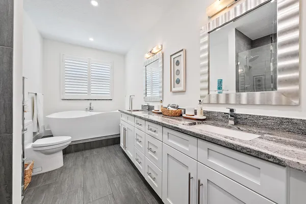 a bathroom with a granite countertop toilet a sink and a bathtub