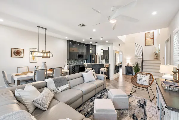 a living room with furniture kitchen view and a chandelier