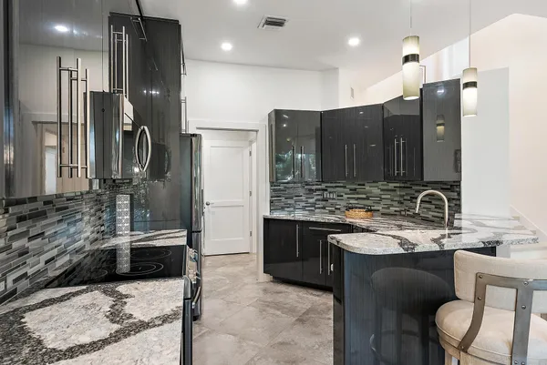 a bathroom with a granite countertop sink a toilet a mirror and shower