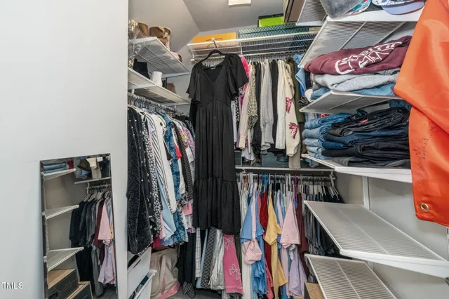 a view of walk in closet with clothes and shoes