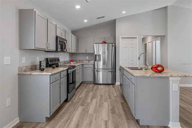 a kitchen with white cabinets and stainless steel appliances