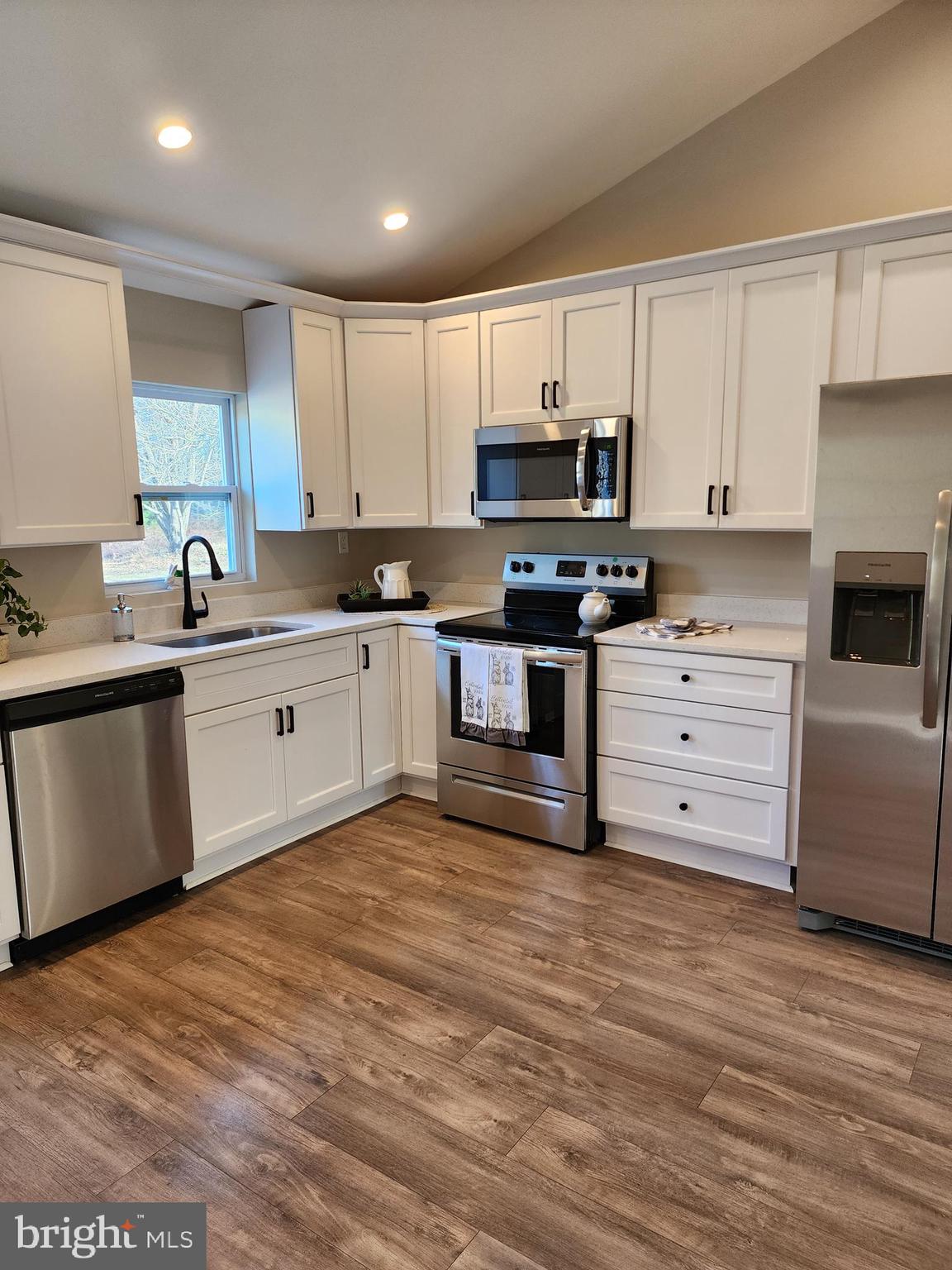 475 Bafford Road Lusby, MD 20657 - Photo 12 of 21 a kitchen with stainless steel appliances granite countertop a stove top oven a sink and white cabinets