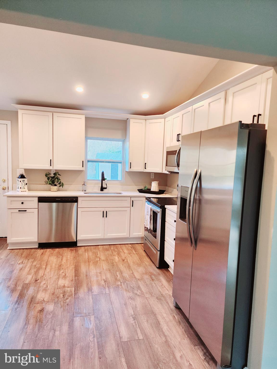 475 Bafford Road Lusby, MD 20657 - Photo 10 of 21 a kitchen with granite countertop a sink stainless steel appliances and white cabinets