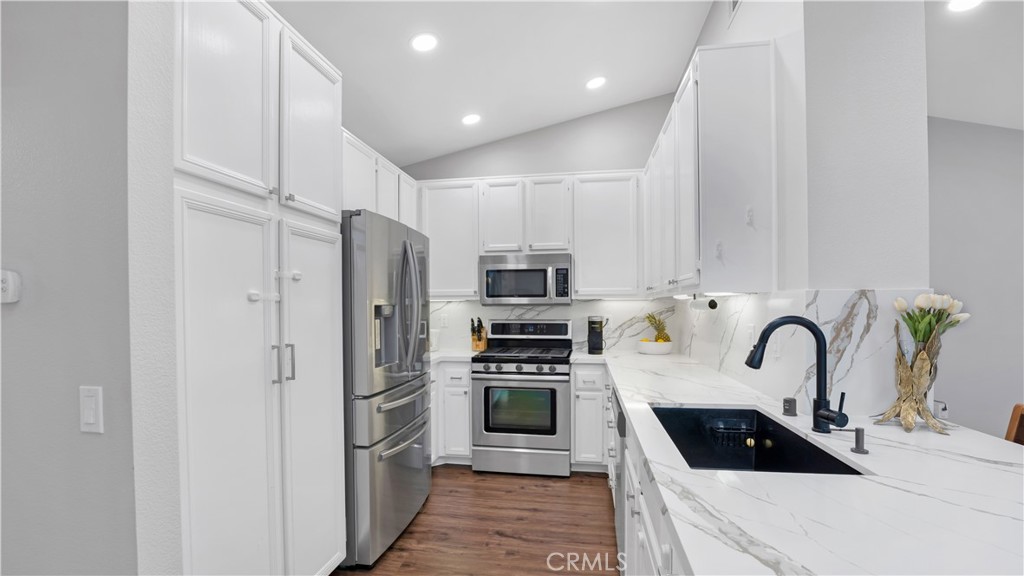 250 Chaumont Circle Lake Forest, CA 92610 - Photo 2 of 28 a kitchen with stainless steel appliances a refrigerator sink and white cabinets