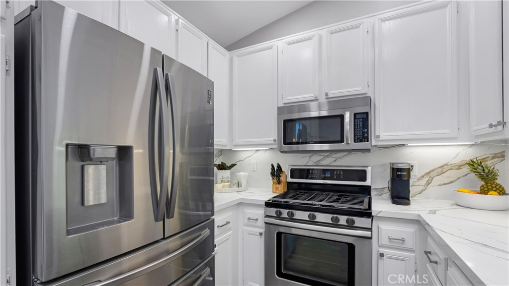 250 Chaumont Circle Lake Forest, CA 92610 - Photo 3 of 28 a kitchen with stainless steel appliances a stove a microwave and a refrigerator