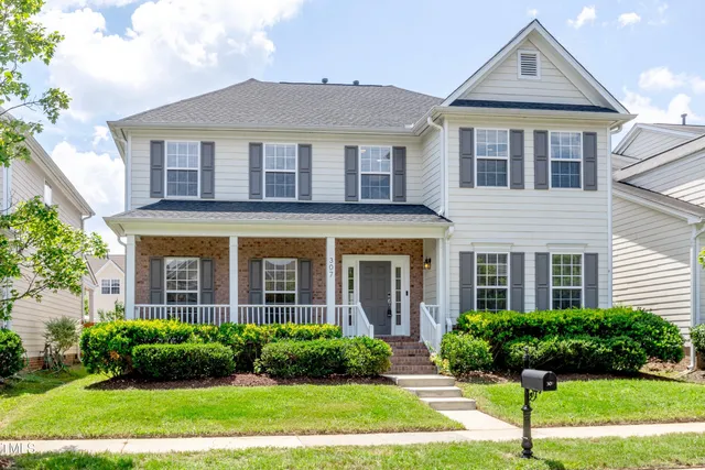 a front view of a house with yard and green space