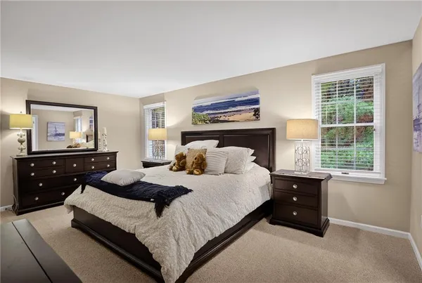 a bedroom with a bed and a dresser next to a window