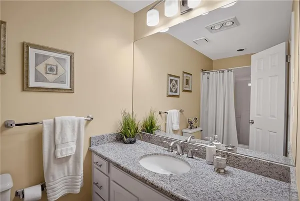 a bathroom with a granite countertop sink and a mirror