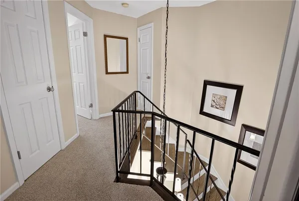 a view of staircase with lots of frames on wall and a window