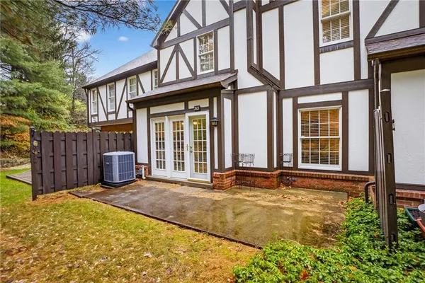 a view of a house with wooden fence and a large tree