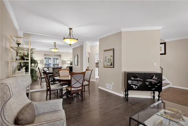 a dining room with furniture a chandelier and wooden floor