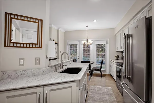 a kitchen with stainless steel appliances granite countertop a refrigerator and a sink