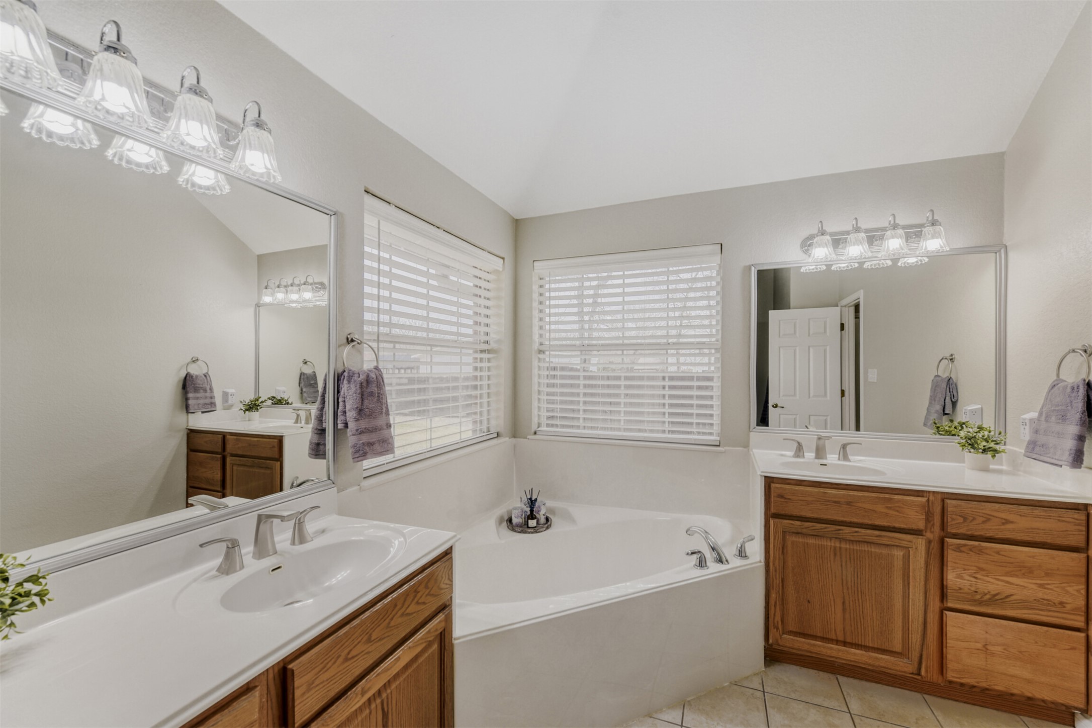104 Spring Branch Bastrop, TX 78602 - Photo 26 of 32 Full bathroom with two vanities, a garden tub, and light tile patterned floors