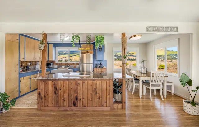 a dining hall with stainless steel appliances granite countertop a couch and chairs