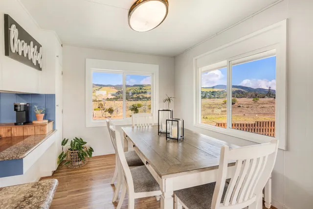 a view of a dining room with furniture a chandelier and wooden floor