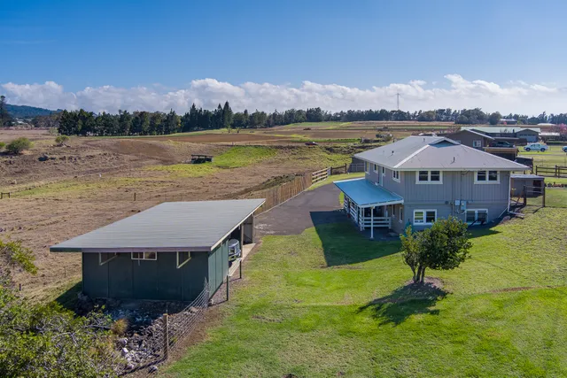 a aerial view of a house with a garden and lake view