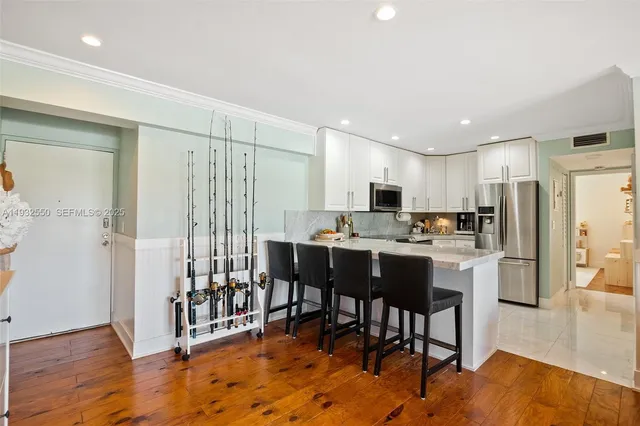 a kitchen with stainless steel appliances kitchen island granite countertop a refrigerator and a stove top oven