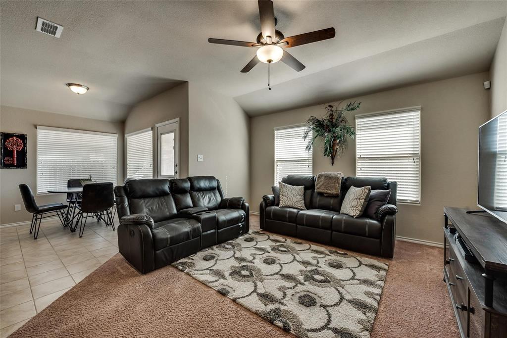 649 Clearbrook Street Azle, TX 76020 - Photo 11 of 28 a living room with furniture a ceiling fan and a flat screen tv