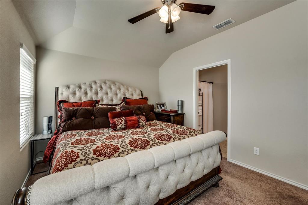 649 Clearbrook Street Azle, TX 76020 - Photo 13 of 28 a bedroom with a large bed and a chandelier