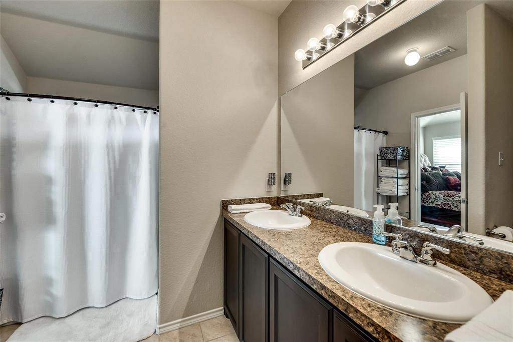 649 Clearbrook Street Azle, TX 76020 - Photo 15 of 28 a bathroom with a granite countertop sink and a mirror