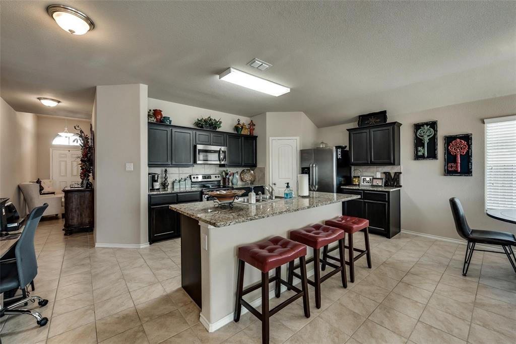 649 Clearbrook Street Azle, TX 76020 - Photo 6 of 28 a kitchen with stainless steel appliances kitchen island granite countertop a sink and cabinets