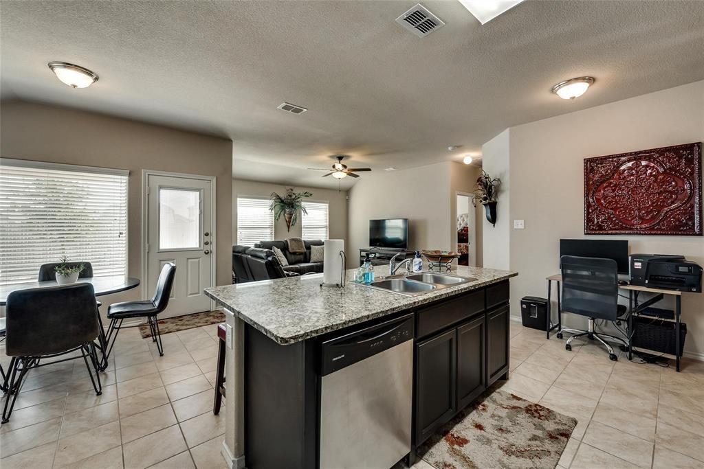 649 Clearbrook Street Azle, TX 76020 - Photo 8 of 28 a kitchen with a stove a counter top space and living room view