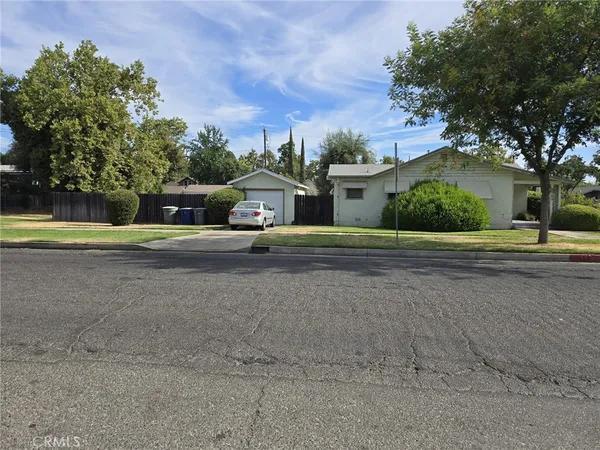 a view of a house with a yard and large trees