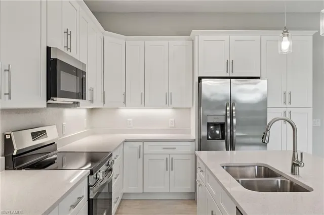 a kitchen with white cabinets and stainless steel appliances