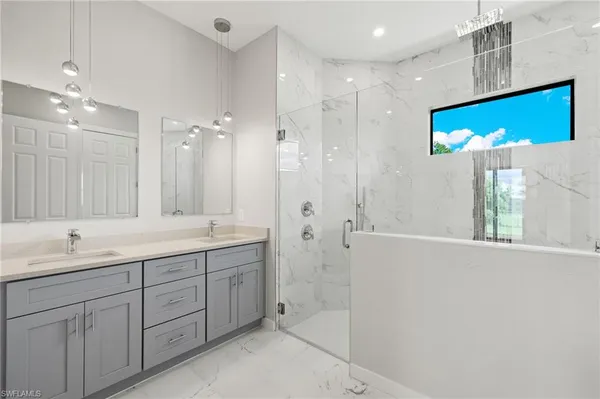 a bathroom with a double vanity sink a large mirror and shower