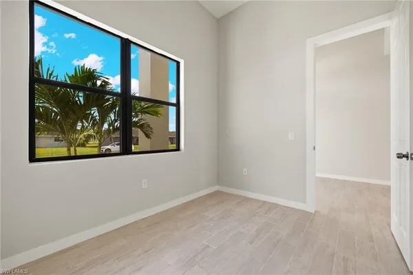 an empty room with wooden floor and painting on the wall
