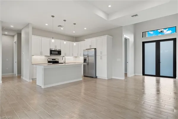 a view of kitchen with refrigerator and microwave