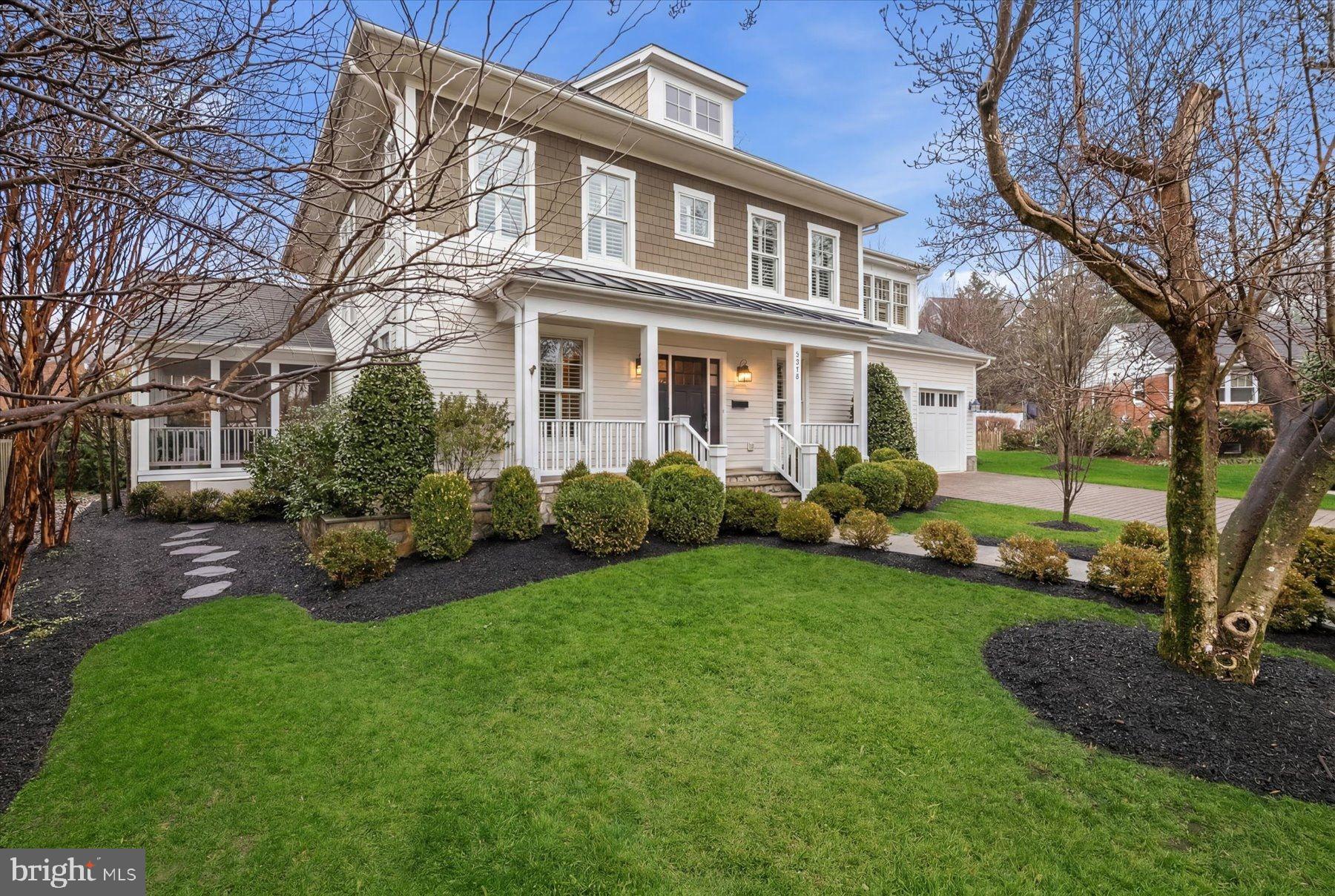 a front view of a house with a yard and trees