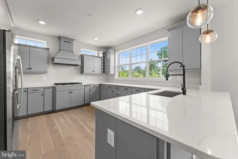 a kitchen with stainless steel appliances a sink window and cabinets
