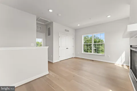 a view of an empty room with a window and fire place